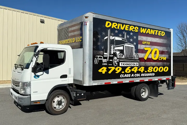 Wrapped box truck with large commercial graphics.