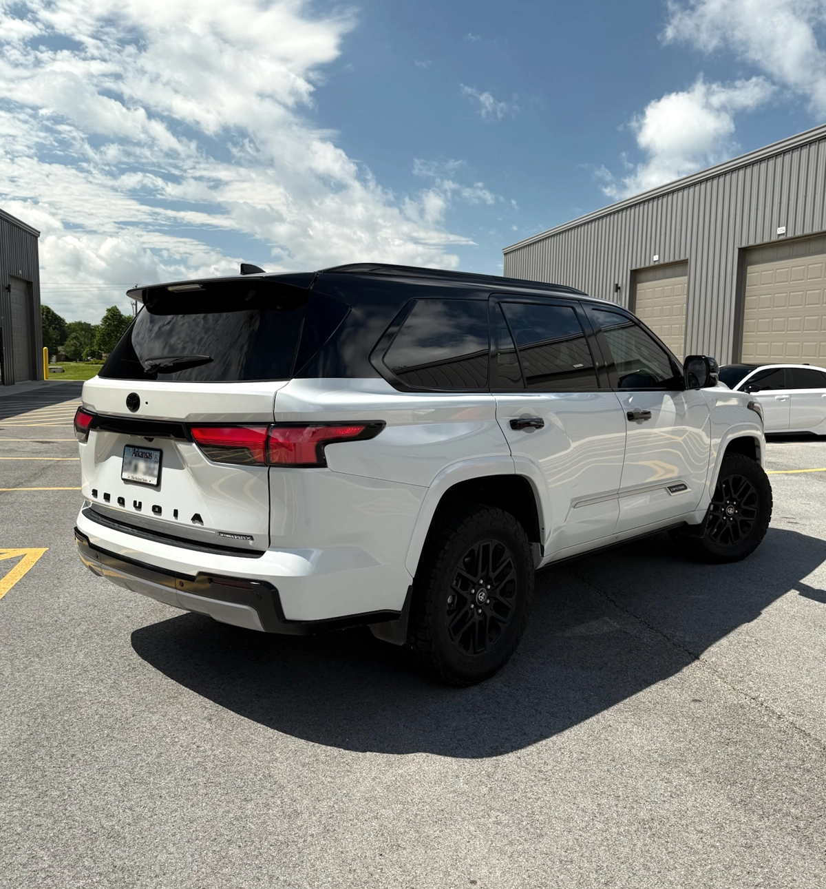 Rear side image of Toyota Capstone with a gloss black tuxedo wrap.